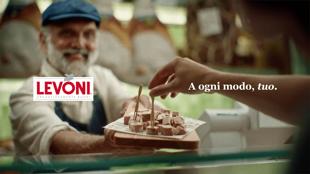 Salumiere che mostra cubetti di mortadella con payoff "Levoni. A ogni modo, tuo"