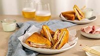 mozzarella in carrozza con prosciutto cotto Levoni, dorata fuori e filante dentro, servita calda su un piatto da aperitivo con crosta croccante e mozzarella che si scioglie e ripiena di prosciutto cotto