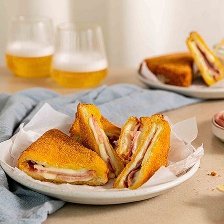 mozzarella in carrozza con prosciutto cotto Levoni, dorata fuori e filante dentro, servita calda su un piatto da aperitivo con crosta croccante e mozzarella che si scioglie e ripiena di prosciutto cotto