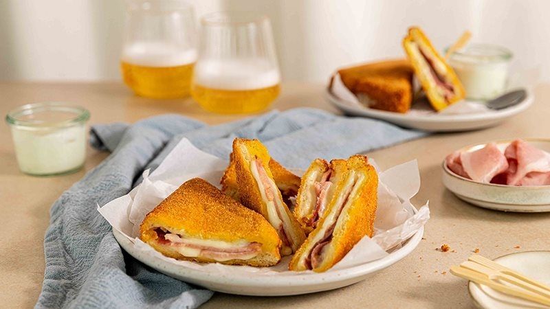 mozzarella in carrozza con prosciutto cotto Levoni, dorata fuori e filante dentro, servita calda su un piatto da aperitivo con crosta croccante e mozzarella che si scioglie e ripiena di prosciutto cotto