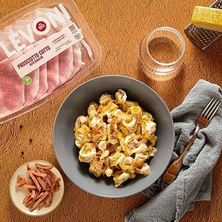 tortellini panna e prosciutto con Prosciutto Cotto Alta Qualità Levoni, cremosi e avvolgenti, serviti caldi in un piatto fondo con panna vellutata e listarelle di prosciutto lucido e morbido.