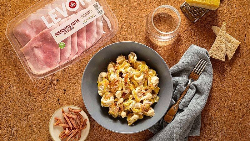 tortellini panna e prosciutto con Prosciutto Cotto Alta Qualità Levoni, cremosi e avvolgenti, serviti caldi in un piatto fondo con panna vellutata e listarelle di prosciutto lucido e morbido.